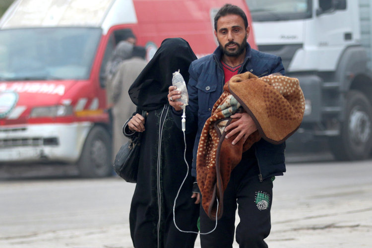 A man carries a child with an IV drip as he flees deeper into the remaining rebel-held areas of Aleppo, Syria, yesterday. (Abdalrhman Ismail/Reuters)</p>  
