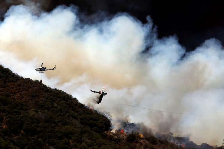 Firefighting helicopters work to tame the blaze&nbsp;in San Bernardino county. (Reuters/Patrick T Fallon</p>  