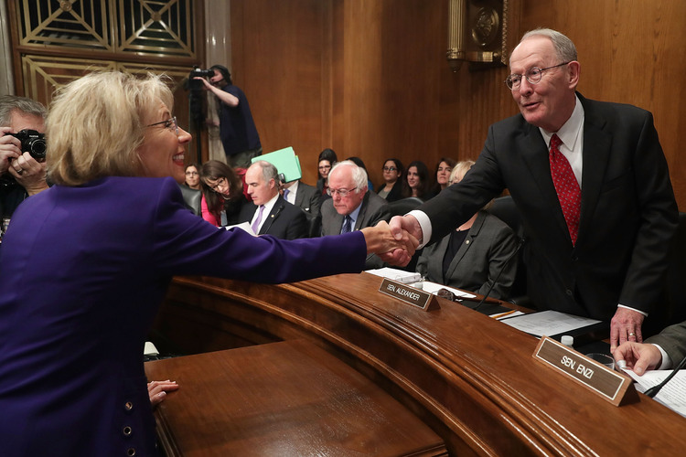 Betsy DeVos, President-elect Trump's pick to be secretary of education, greets Lamar Alexander last night before her confirmation hearing. (Chip Somodevilla/Getty Images)</p>