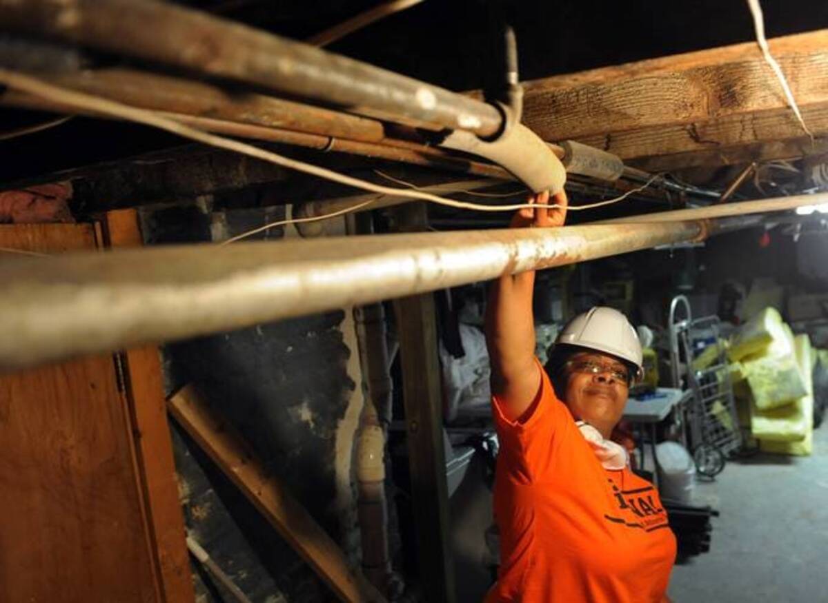 Rashae Foster prepares to insulate basement water pipes at a D.C. home. (Jahi Chikwendiu/The Washington Post)&nbsp;