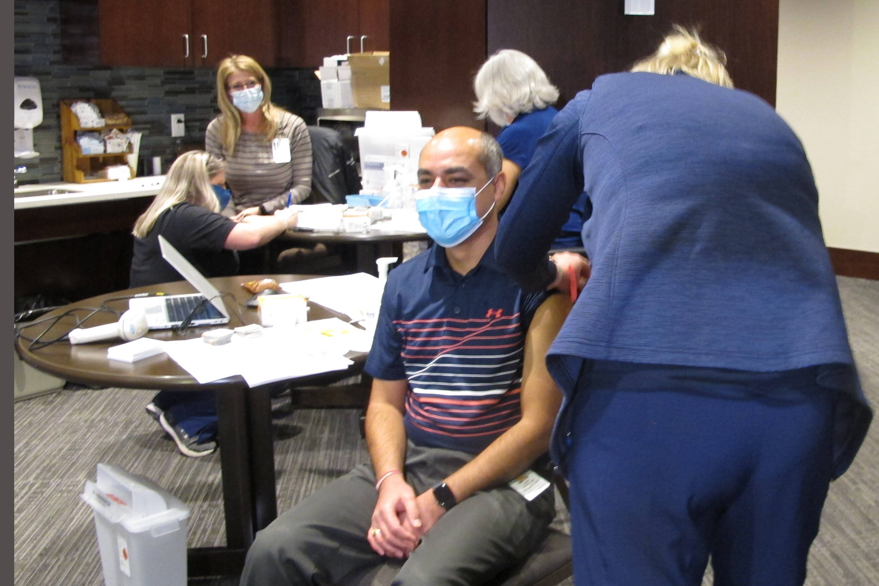Physician Avish Nagpal, who treats patients in Fargo, N.D., receives the first shot of the coronavirus vaccine given in North Dakota on Monday. (Dave Kolpack/AP)
