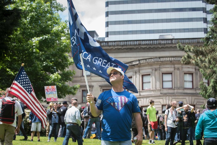 Don Wayne waves a Make America Great flag during a pro-Trump rally in Portland, Oregon. (Ariane Kunze/AFP/Getty Images)</p>  