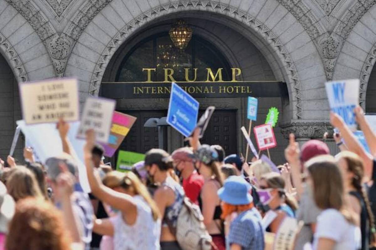 Protesters march past the Trump International Hotel. (Photo by MANDEL NGAN/AFP via Getty Images)