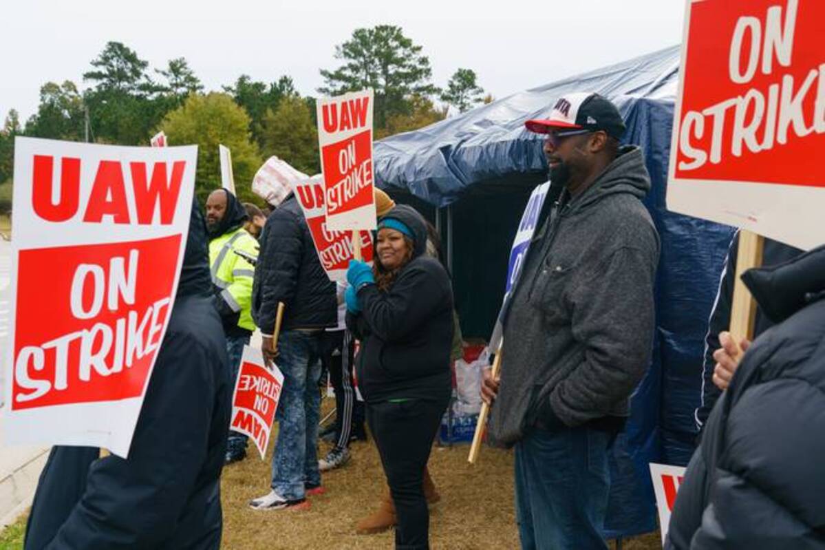 Workers hold signs during a strike outside the John Deere Regional Parts Distribution facility in McDonough, Ga., on Friday. (Elijah Nouvelage/Bloomberg News)