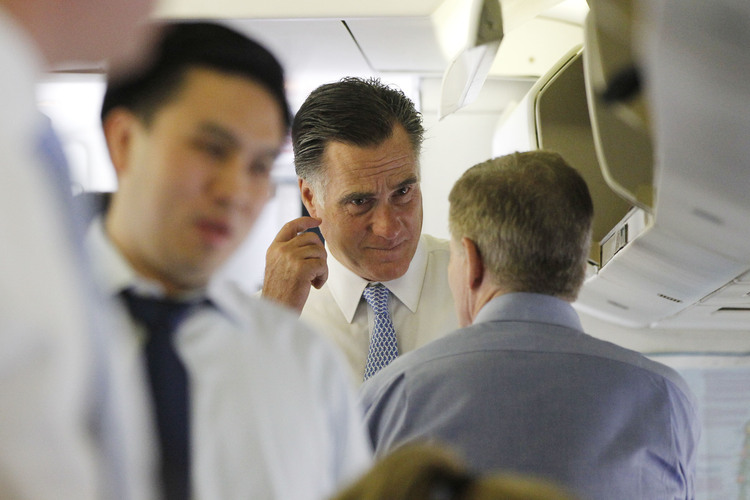 Mitt Romney talks to Stuart Stevens,&nbsp;as Lanhee Chen is seen at left, on a charter flight in July 2012. (Charles Dharapak/AP)</p>  