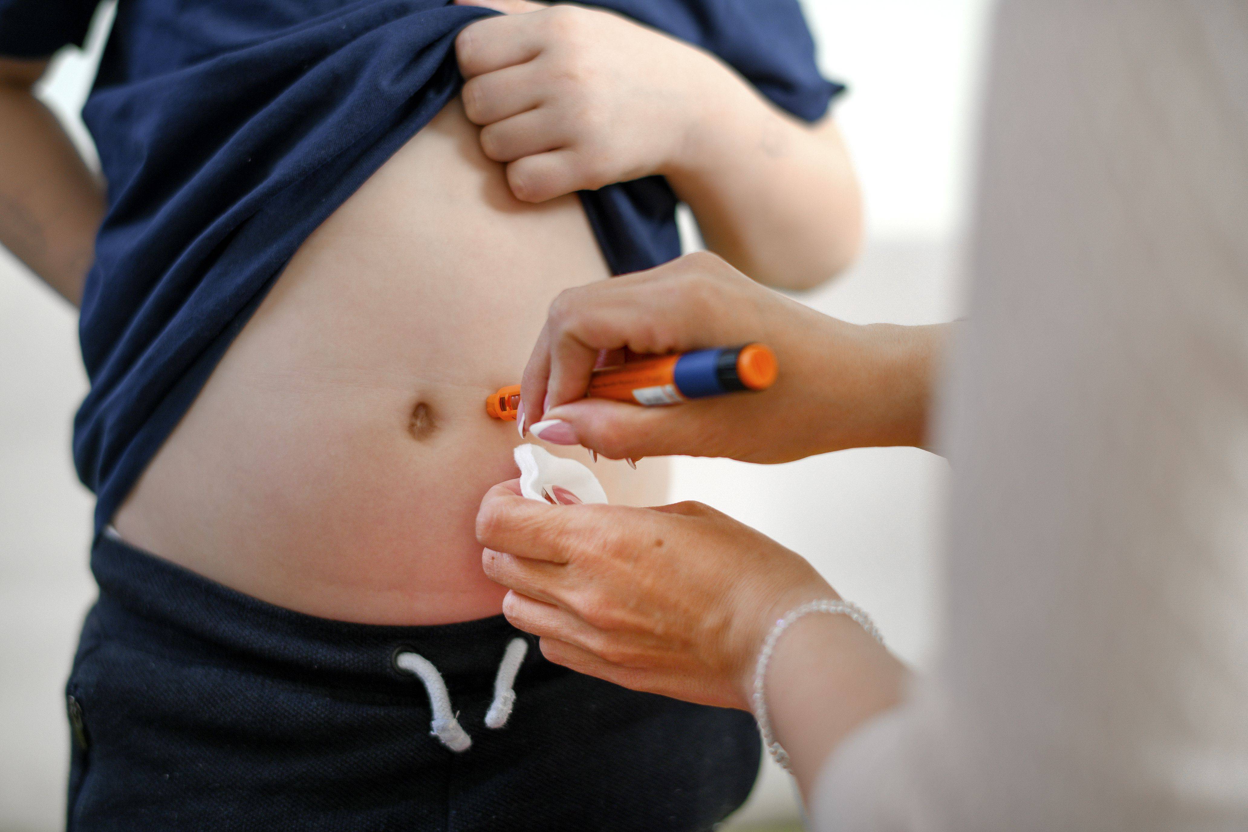A young boy gets insulin shot in stomach. (iStock)