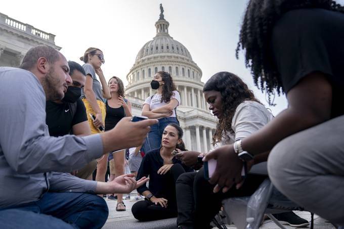 Rep. Alexandria Ocasio-Cortez (D-N.Y.), center left, speaks to Rep. Cori Bush (D-Mo.) while protesting the expiration of the eviction moratorium outside of the Capitol (Photographer: Stefani Reynolds/Bloomberg)