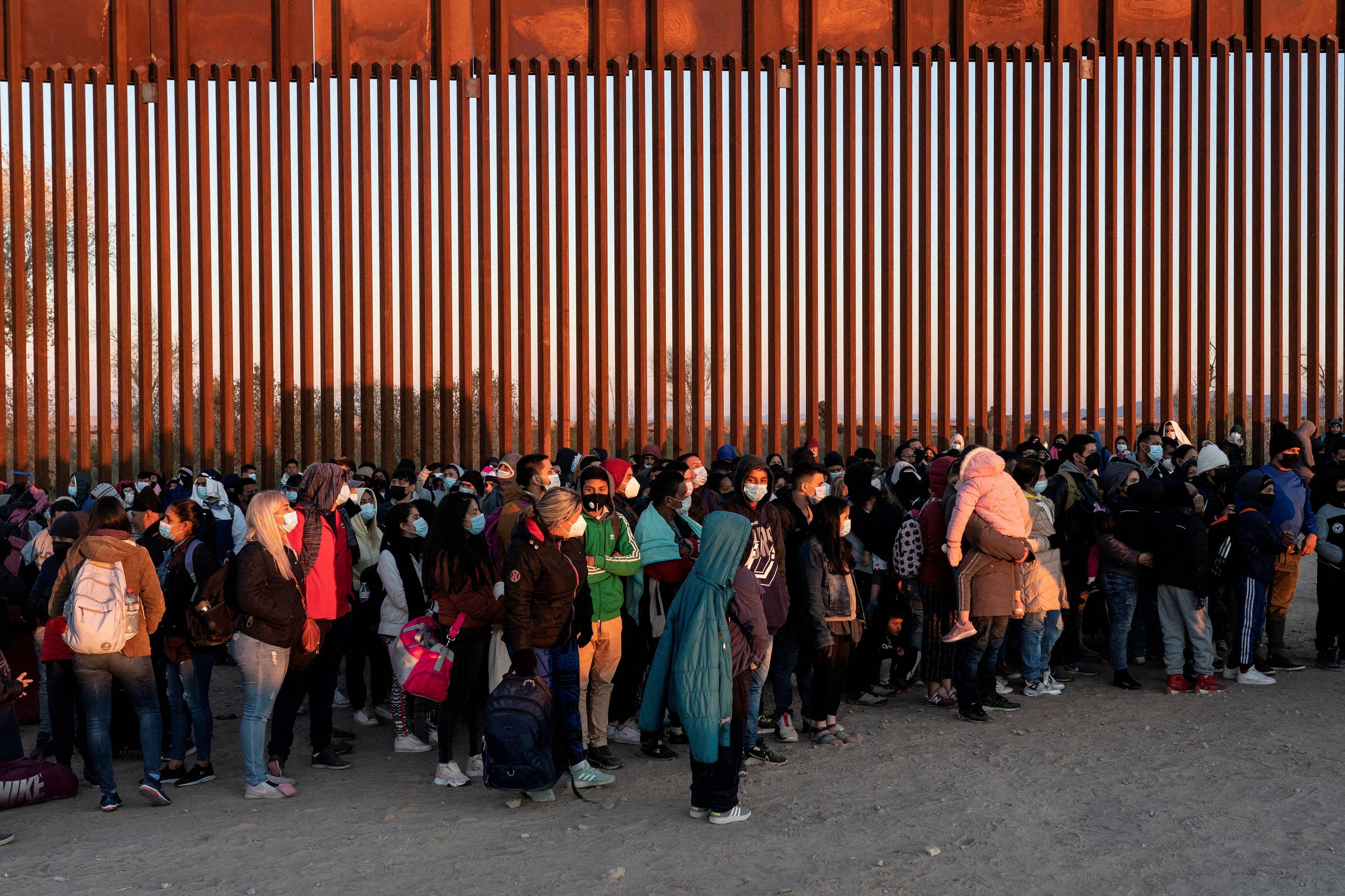 Migrants seeking asylum in the United States, mostly from Venezuela, wait to be processed by the U.S. Border Patrol after crossing the border from Mexico at Yuma, Ariz., on Jan. 23. (Go Nakamura/Reuters)
