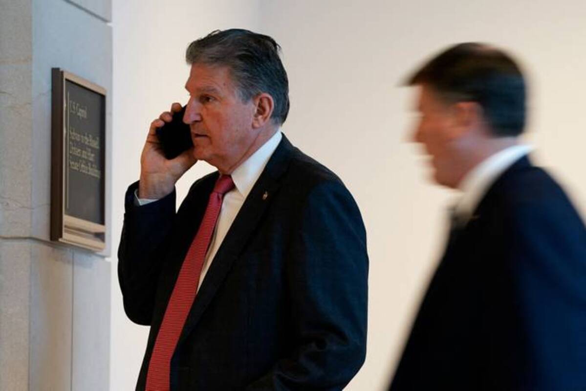 U.S. Sen. Joe Manchin III (D-W.Va.) speaks on his phone in a hallway on Feb. 3. (Elizabeth Frantz/Reuters)