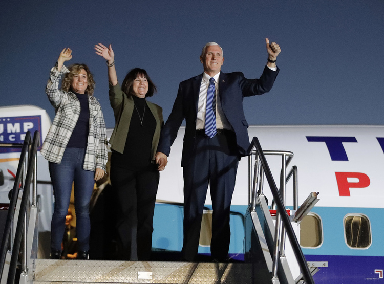 Mike Pence and his wife, Karen, and daughter, Charlotte, acknowledge supporters as they get off a plane after arriving for a big rally last night in Indianapolis. (Darron Cummings/AP)</p>  