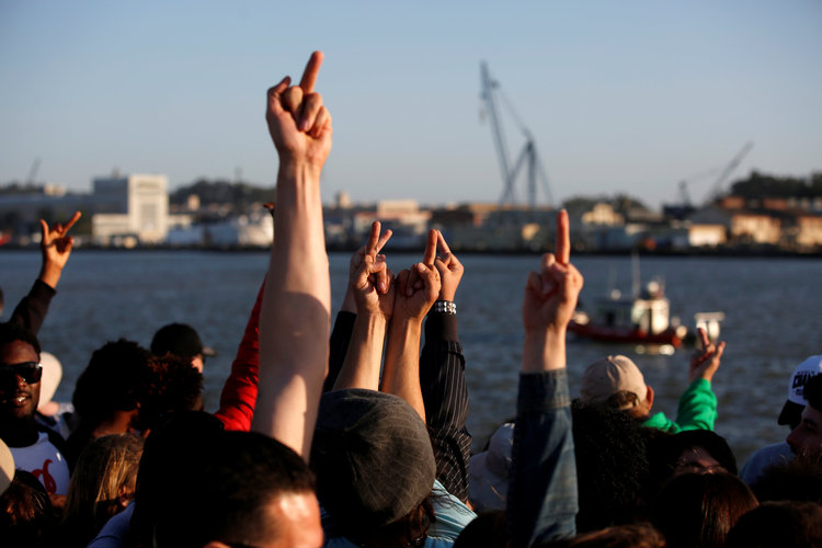 Bernie supporters gesture to a boat with a sign in support of Trump during a rally yesterday in Vallejo, California. (Reuters/Stephen Lam)</p>  