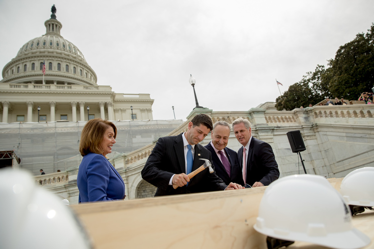 In September, Nancy Pelosi and Mitch McConnell watch as Paul Ryan hammers in a nail for Chuck Schumer after he bent his during a ceremony to drive in the first nails to signify&nbsp;the start of construction on the 2017 presidential inaugural platform. (Andrew Harnik/AP)</p>  