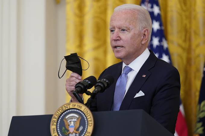 President Biden holds a face mask as he announces that millions of federal workers must show proof they've received a coronavirus vaccine or submit to regular testing and stringent social distancing, masking and travel restrictions in an order to combat the spread of the coronavirus. (Susan Walsh/AP)