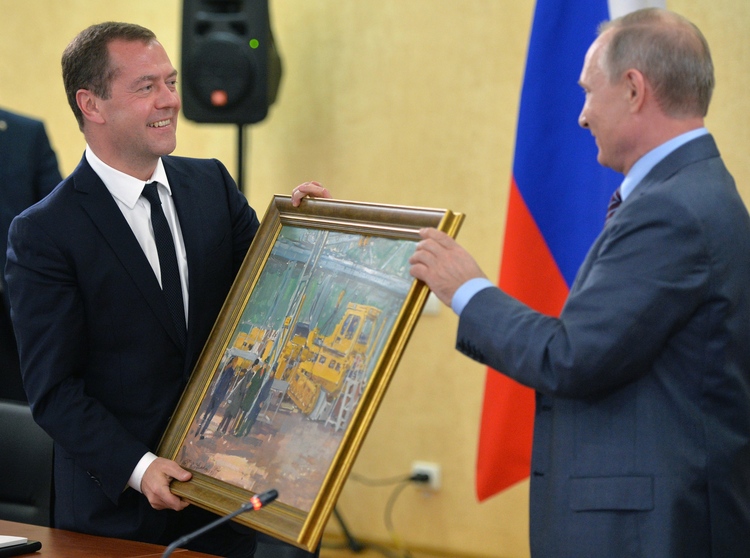 Vladimir Putin presents Prime Minister Dmitry Medvedev with a painting yesterday to mark his 51st birthday while they visited Kerch, Crimea. (Alexei Druzhinin/Pool Photo via AP)</p>