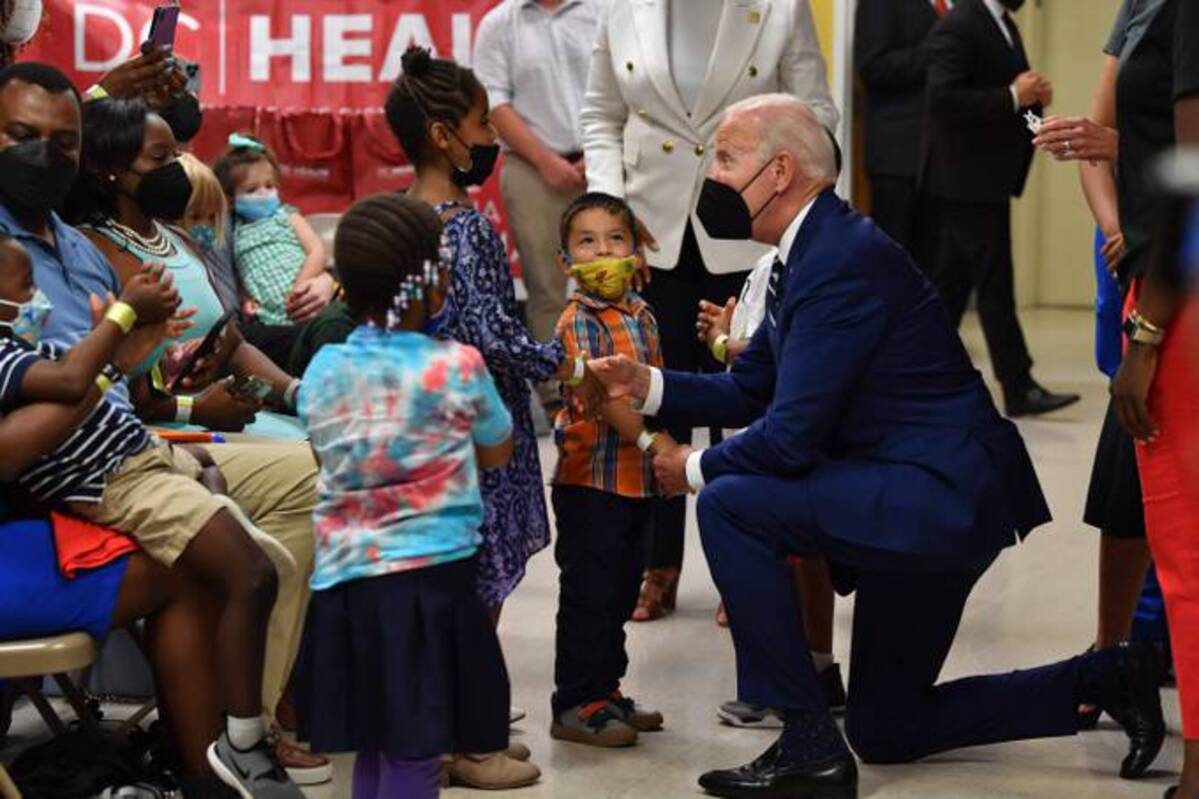 President Biden greets children during a visit at a covid-19 vaccination clinic at the Church of the Holy Communion in Washington, D.C., on Tuesday. (Nicholas Kamm / AFP via Getty Images)