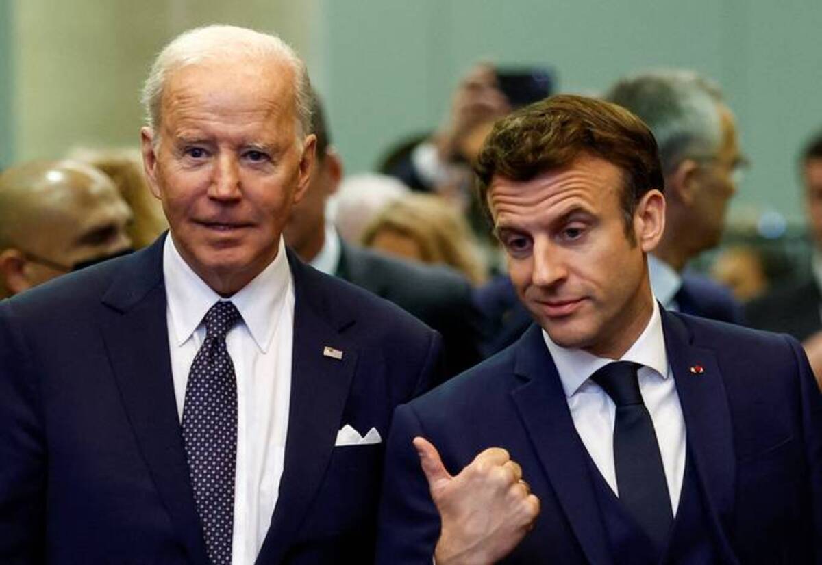 France President Emmanuel Macron gestures next to President Biden on Thursday during a NATO summit to discuss Russia's invasion of Ukraine at the alliance's headquarters in Brussels. (Gonzalo Fuentes/Reuters)