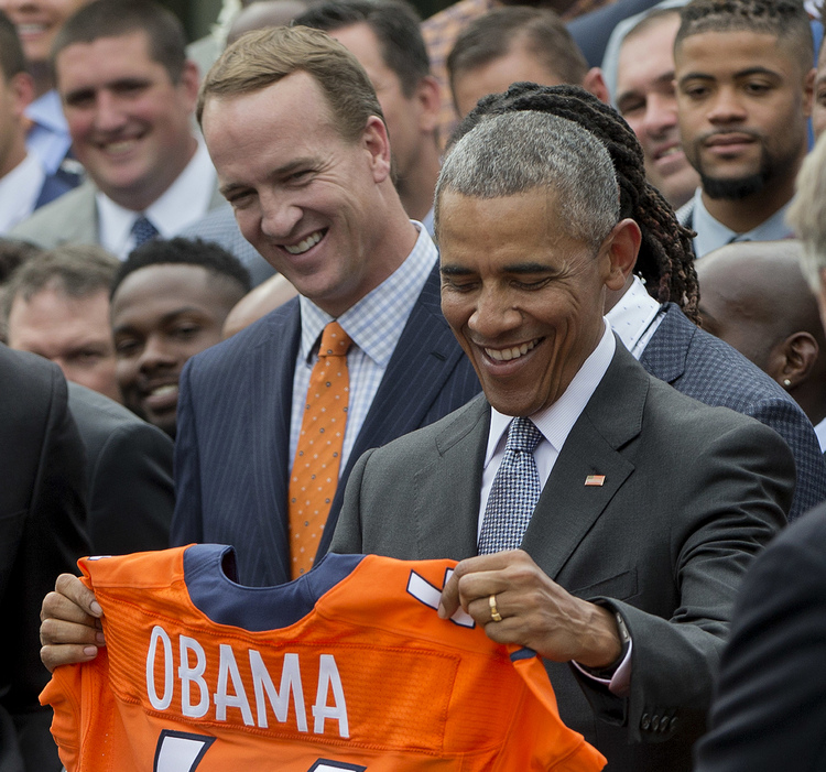 Barack Obama holds up a Denver Broncos jersey as he welcomes the Super Bowl Champions during a ceremony in the Rose Garden yesterday. Standing behind the president is Peyton Manning. (AP Photo/Pablo Martinez Monsivais)</p>  
