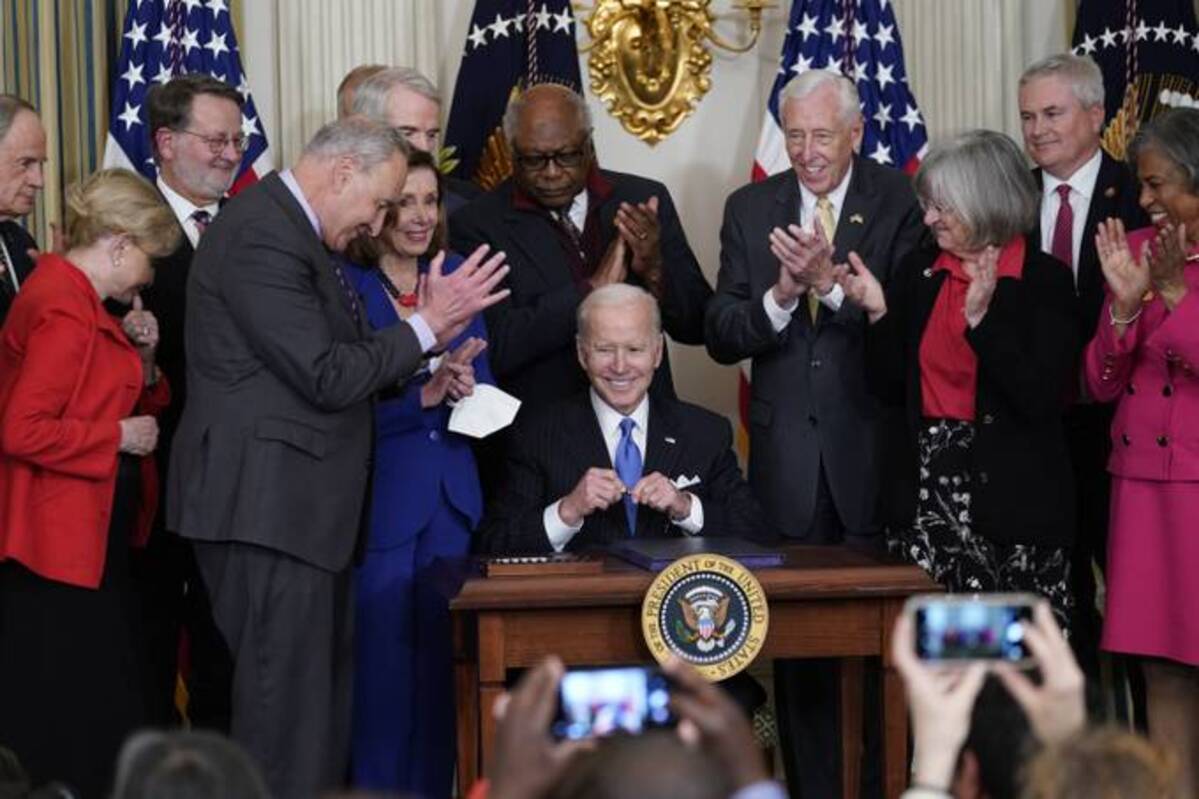 President Biden signs the Postal Service Reform Act of 2022 in the State Dining Room at the White House on Wednesday (Susan Walsh/AP)