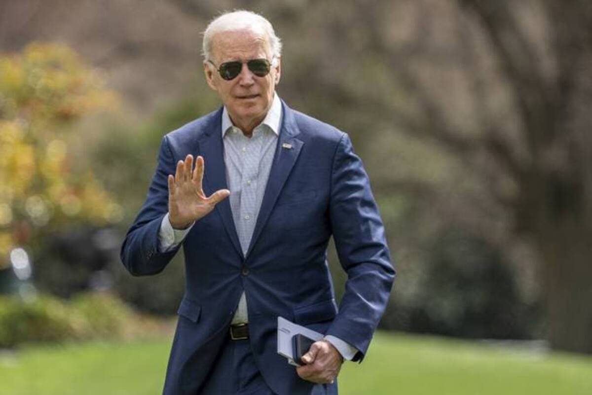 President Biden waves to the media after walking off Marine One on the South Lawn of the White House on Sunday. (Ken Cedeno/EPA-EFE/Shutterstock)