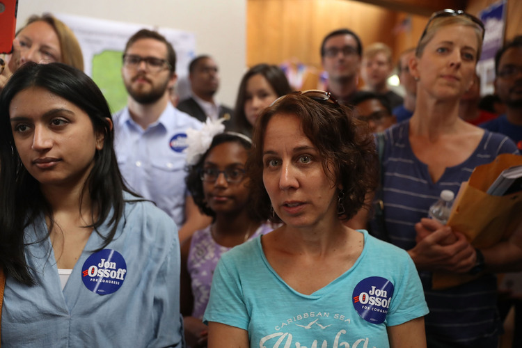 Volunteers listen as Ossoff thanks them during a stop at his campaign office in Sandy Springs yesterday. (Joe Raedle/Getty Images)</p>  