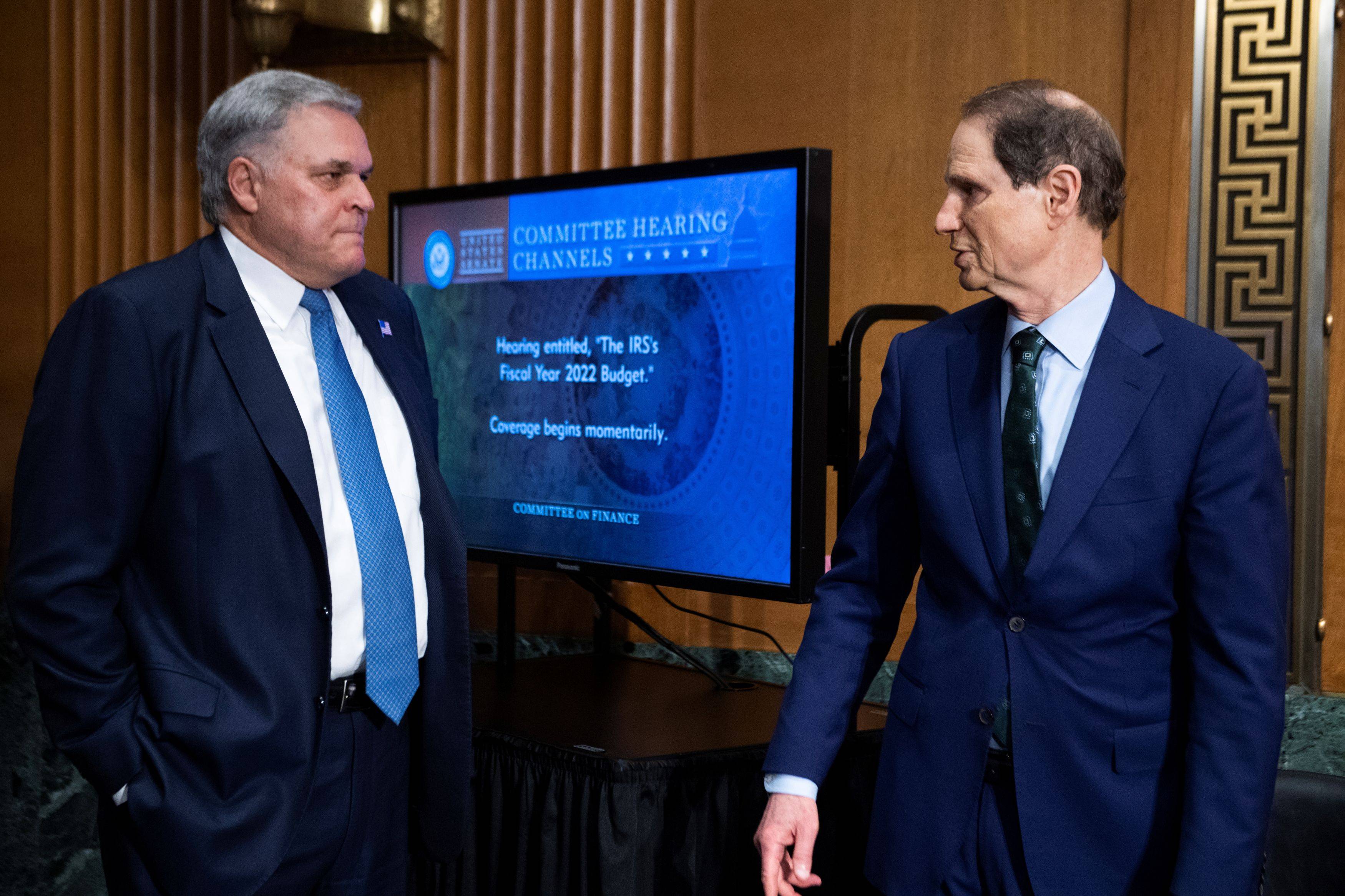 Charles P. Rettig, commissioner of the Internal Revenue Service, greets Sen. Ron Wyden (D-Ore.), before testifying during a Senate Finance Committee hearing in June. (Tom Williams/Pool/Reuters)