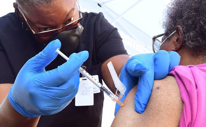 Vocational nurse Eon Walk administers the Pfizer coronavirus vaccine at a mobile vaccine clinic hosted by Mothers in Action and operated by the Los Angeles County of Public Health on Friday in Los Angeles. &nbsp;(Frederic J. Brown/AFP/Getty Images)&nbsp;