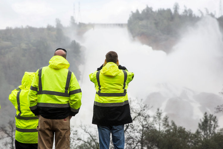 A crew monitors water flowing through a damaged spillway on the Oroville Dam. (Reuters/Max Whittaker)</p>  