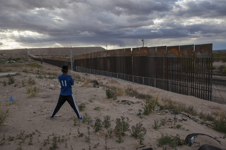 A youth looks at a new, taller fence being built along U.S.-Mexico border in Ciudad Juarez, Mexico. (Rodrigo Abd/AP)  