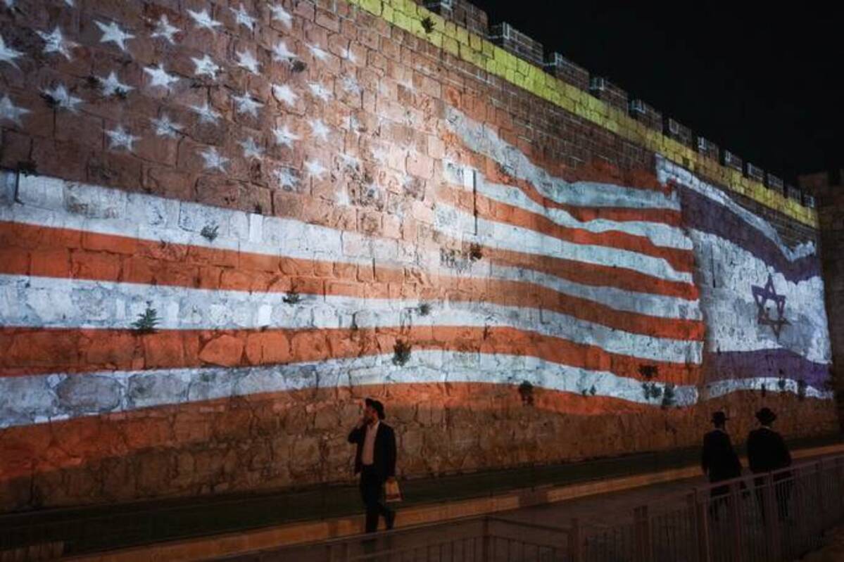 Israeli authorities project an image of the Israeli and U.S. flags on the walls of Jerusalem's Old City in honor of July 4th. President Joe Biden is set to visit Israel and the occupied West Bank next week as part of a broader trip to the Middle East. (AP Photo/Mahmoud Illean)