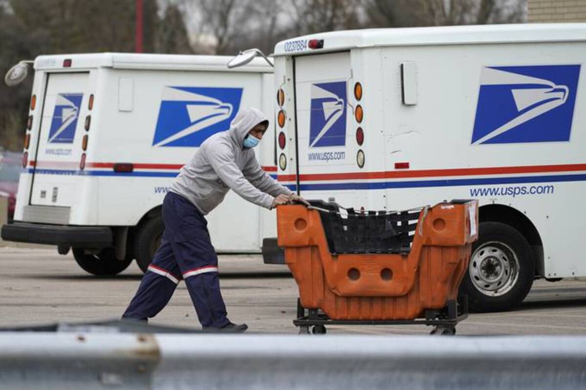 A USPS employee works outside a post office facility in Wheeling, Ill., on Dec. 3, 2021. (Nam Y. Huh/AP)