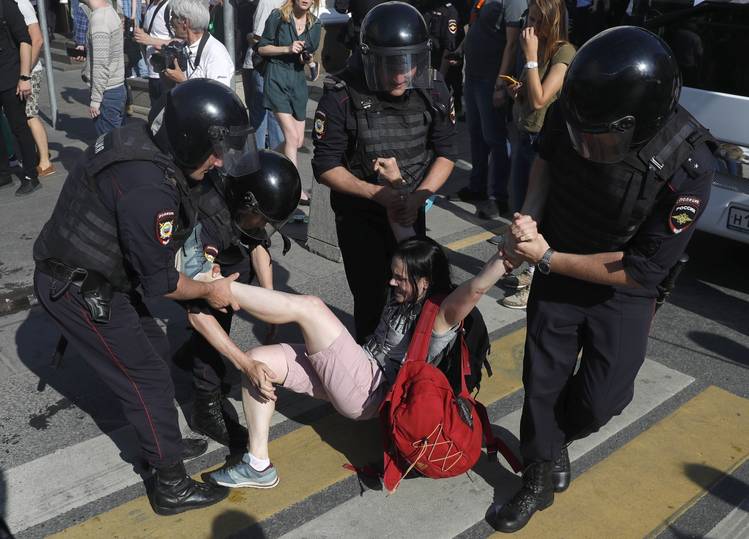 Police detain a woman during the protest in Moscow on Saturday. (Pavel Golovkin/AP)  