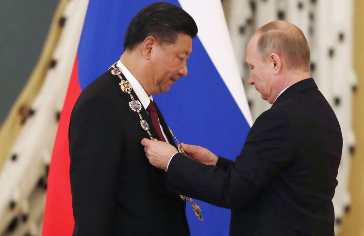 Vladimir Putin awards Chinese leader Xi Jinping the Order of St. Andrew the Apostle the First-Called during a ceremony at the Kremlin in Moscow yesterday. (Sergei Ilnitsky/AFP/Getty Images)</p>