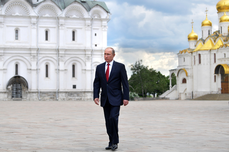 Vladimir Putin walks in the Cathedral Square of the Kremlin. (Alexei Druzhinin/Sputnik/AP)</p>  