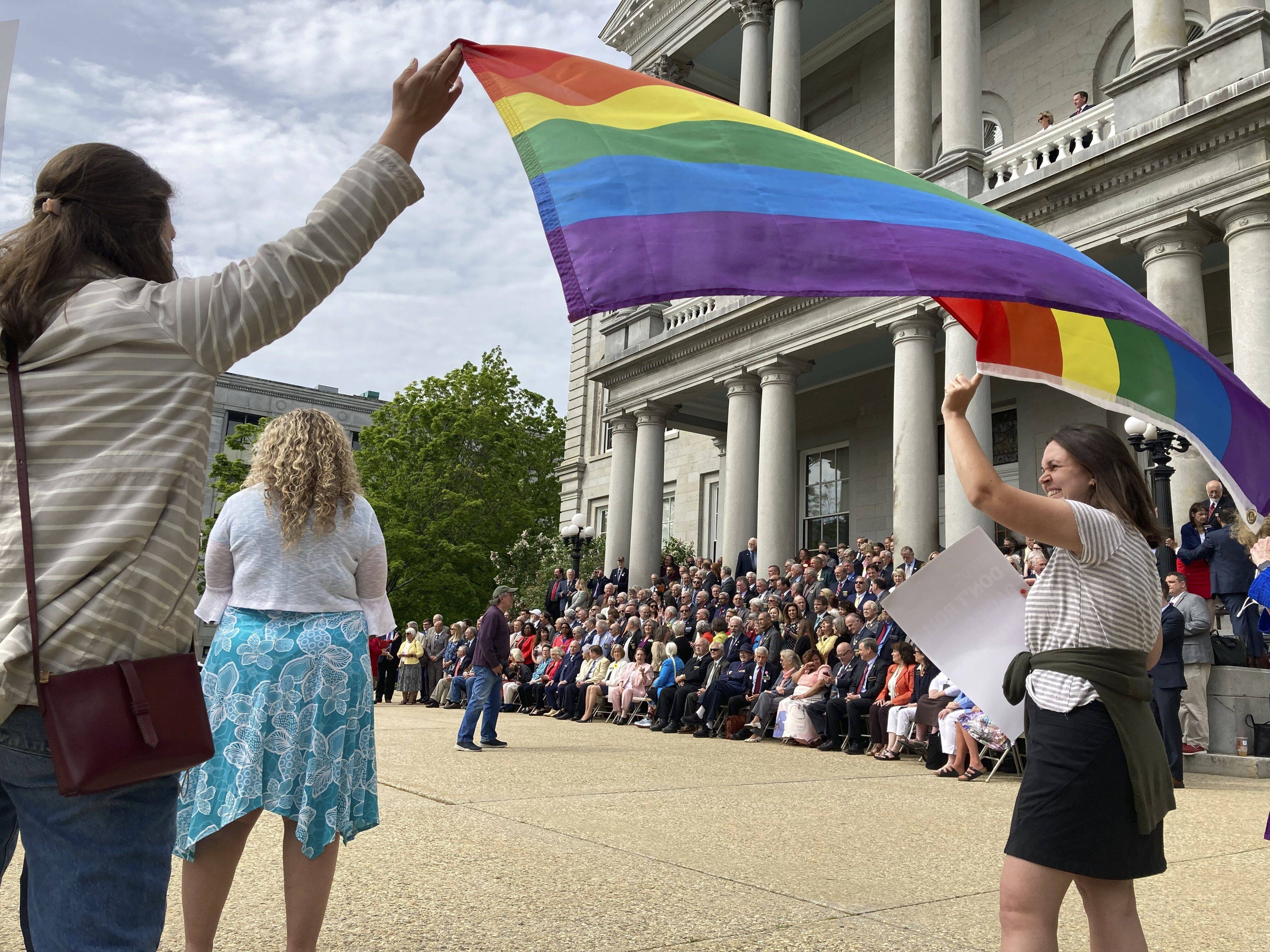 Activists gather outside the New Hampshire Statehouse on Thursday as the 400-member House poses for a class photo on the last day of the legislative session. (AP Photo/Holly Ramer)