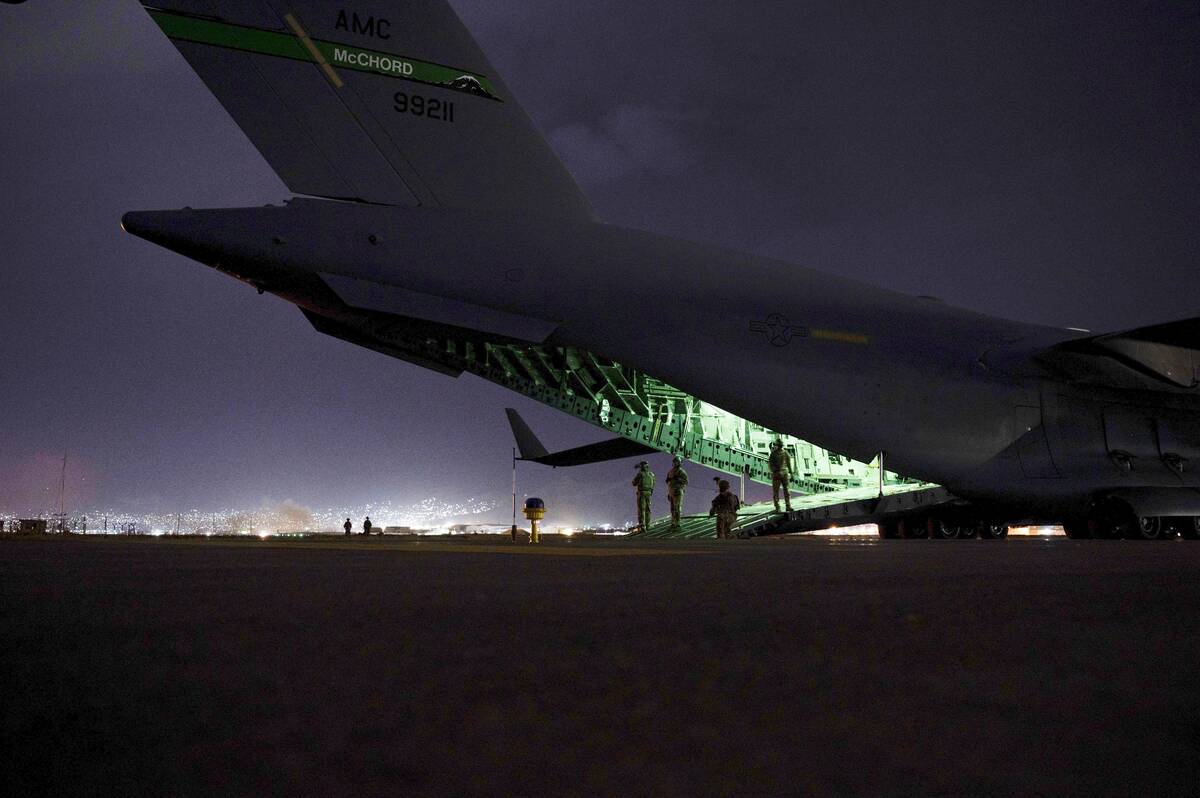 An Air Force aircrew prepares to receive soldiers to board a U.S. Air Force C-17 Globemaster III aircraft for the final noncombatant evacuation from Hamid Karzai International Airport in Kabul, Afghanistan on Aug. 30, 2021. (Senior Airman Taylor Crul/U.S. Air Force via AP)