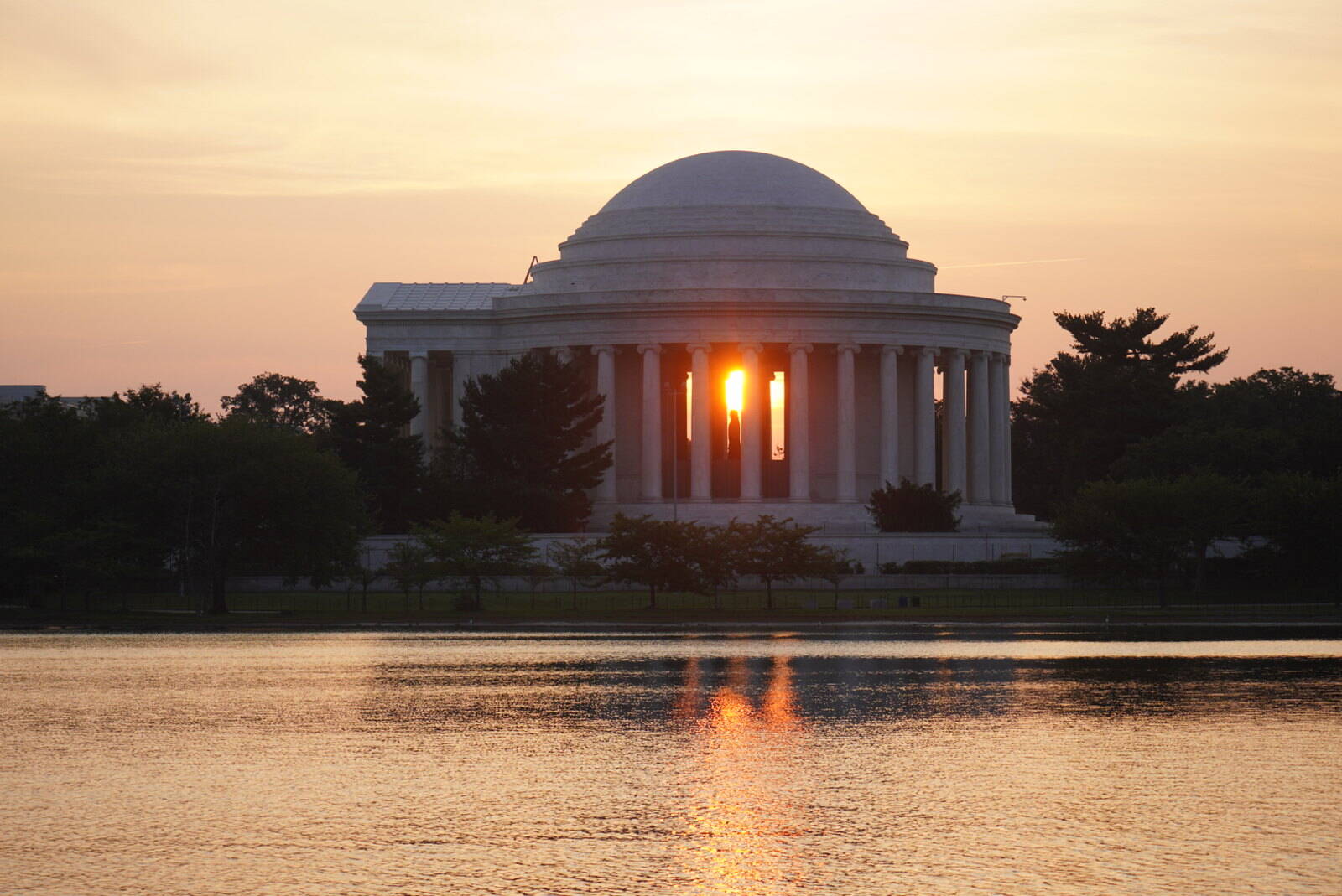Sun rising directly behind the Jefferson Memorial.