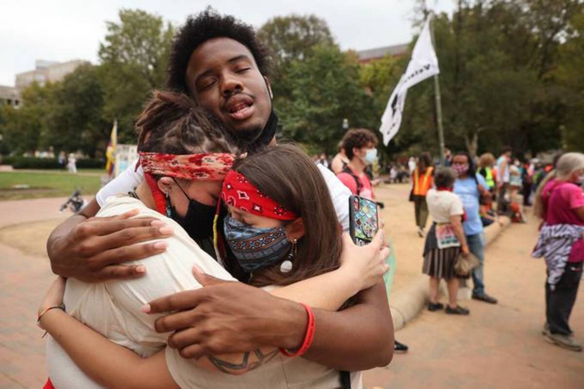 Demonstrators comfort one another while rallying outside the White House during the 'Climate Chaos Is Happening Now' protest on Oct. 13 in Washington, D.C. (Chip Somodevilla/Getty Images)