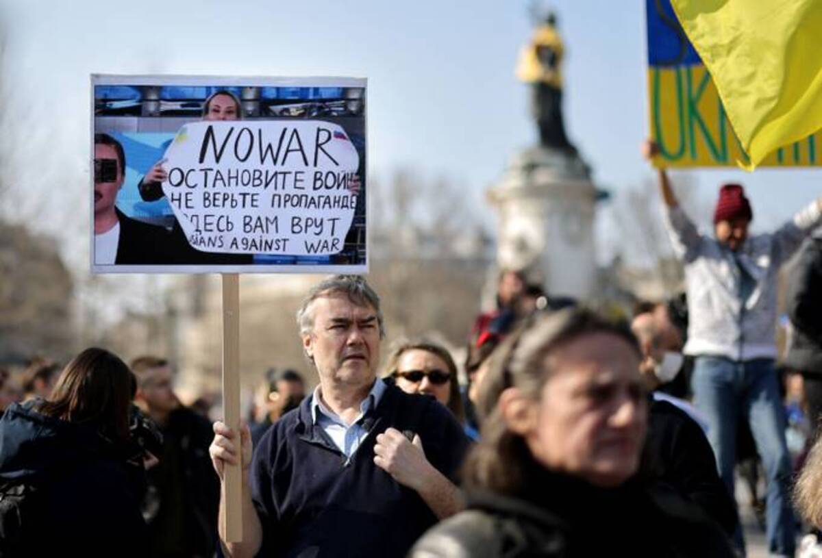 During a rally in support of Ukraine, a protester holds a placard depicting Russian Channel One editor Marina Ovsyannikova's war protest. (Thomas Coex/AFP via Getty Images)