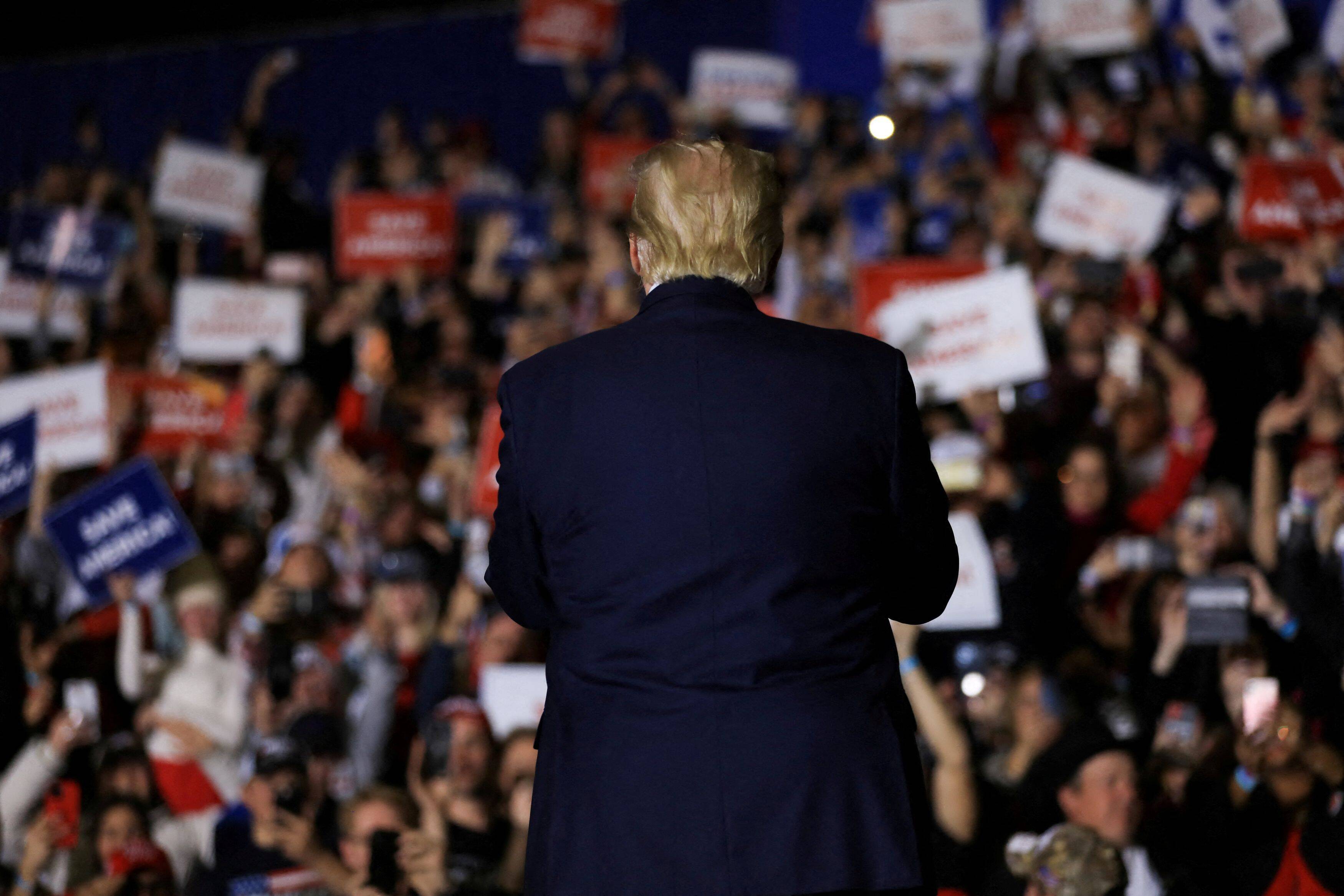 Former president Donald Trump claps with attendees as he makes his entrance into a rally held in Washington Township, Mich., on Saturday. (Emily Elconin/Reuters)