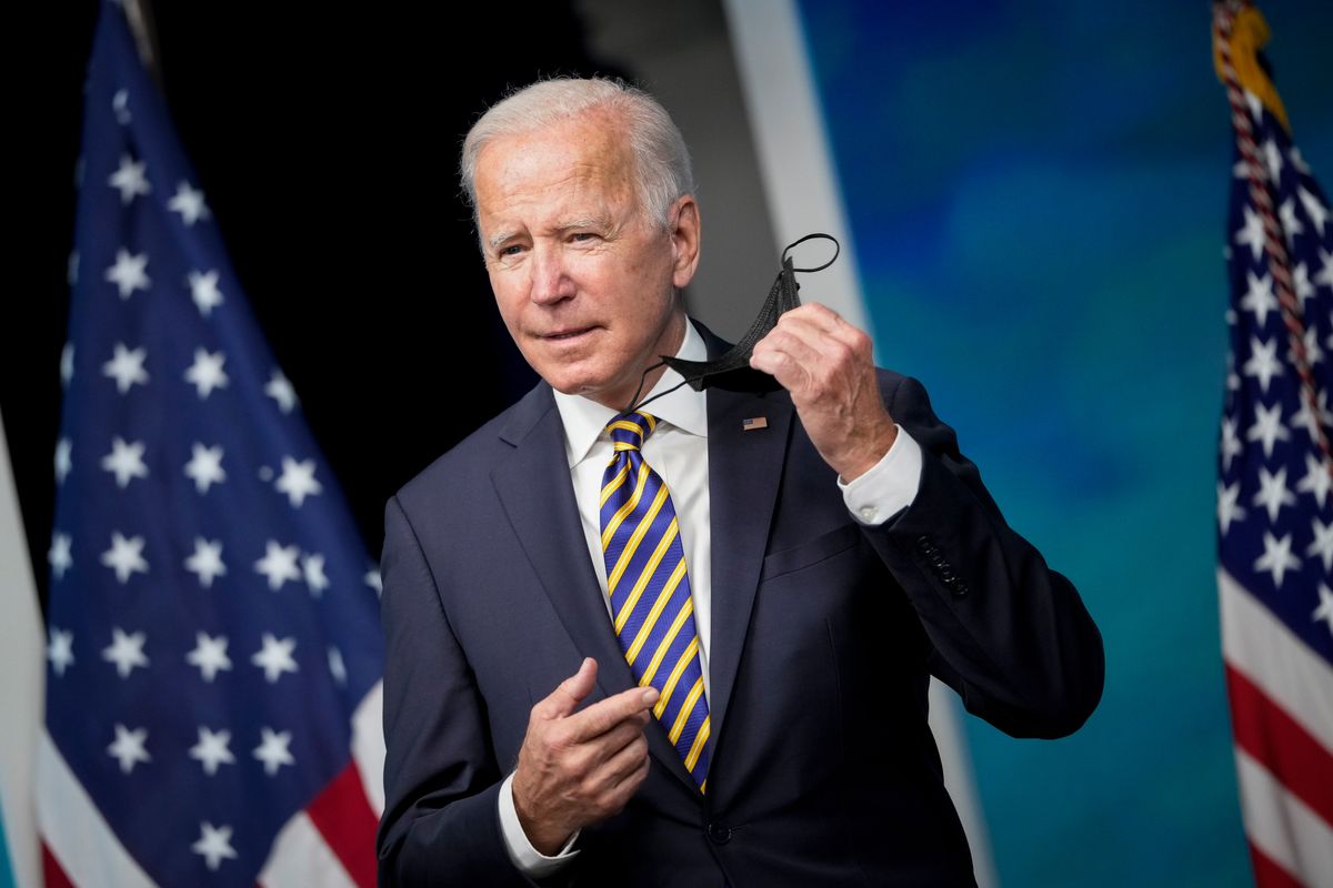 President Biden removes his face mask as he arrives to speak in the South Court Auditorium on the White House campus in October 2021. (Drew Angerer/Getty Images)