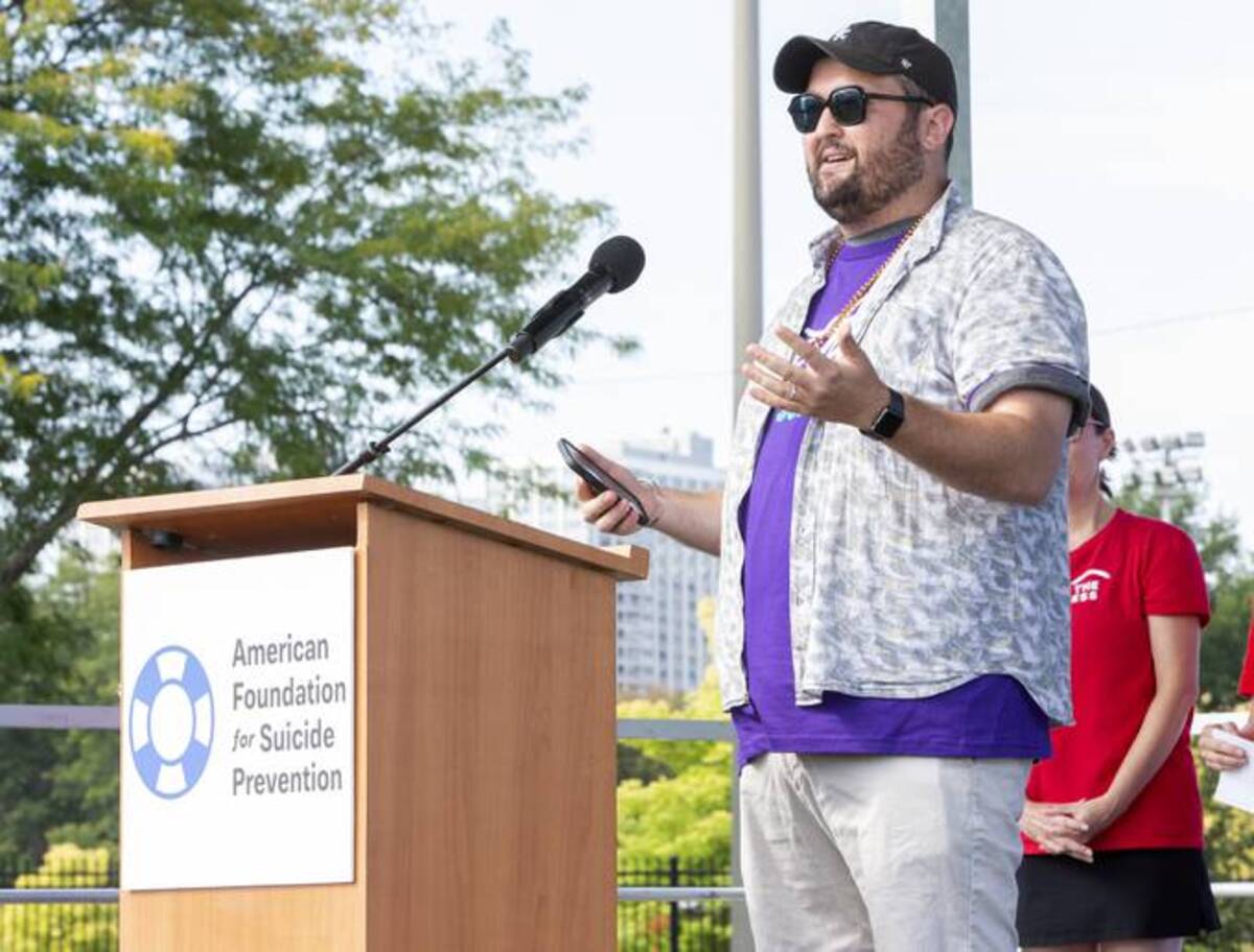 Sean Connolly, outreach coordinator for Illinois Chapter LGBTQ, on stage during the Out of the Darkness Chicagoland Walk at Montrose Harbor. (Barry Brecheisen/Getty Images/American Foundation for Suicide Prevention)