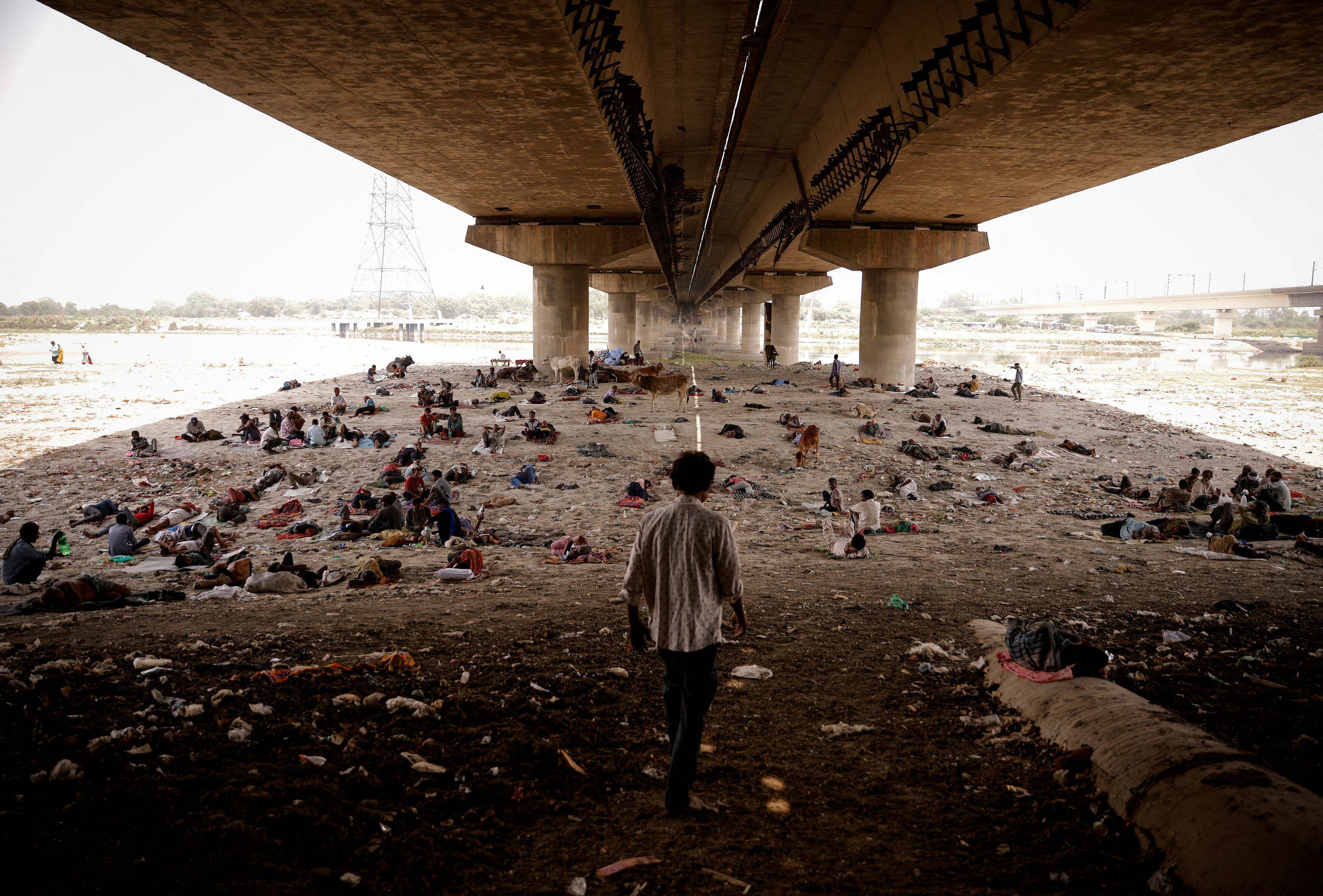 People sit under a bridge along the Yamuna River on a hot summer day in New Delhi on May 2. (Adnan Abidi/Reuters)