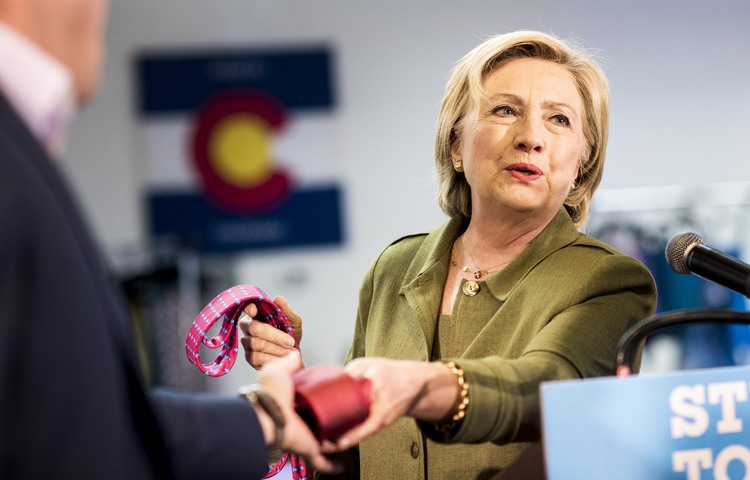 Clinton holds Trump and Clinton designed ties while visiting the Denver-based&nbsp;Knotty Tie Company.&nbsp;(Melina Mara/The Washington Post)</p>  