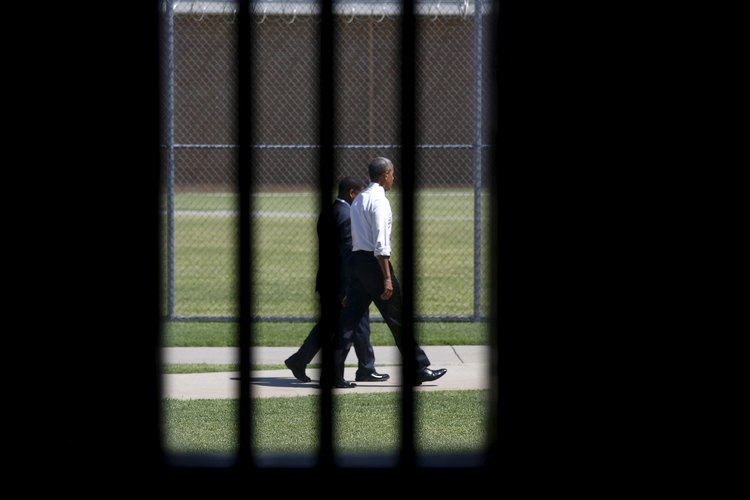 Photographed through a prison cell window, President Barack&nbsp;Obama tours the El Reno Federal Correctional Institution last summer. (Reuters/Kevin Lamarque)</p>  