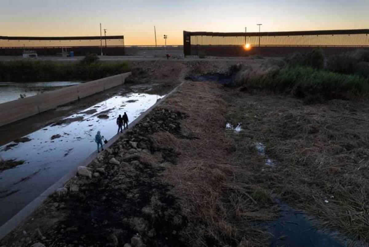 An immigrant family from Haiti walks towards a gap in the U.S. border wall from Mexico on December 11, 2021 in Yuma, Arizona. &nbsp;(Photo by John Moore/Getty Images)