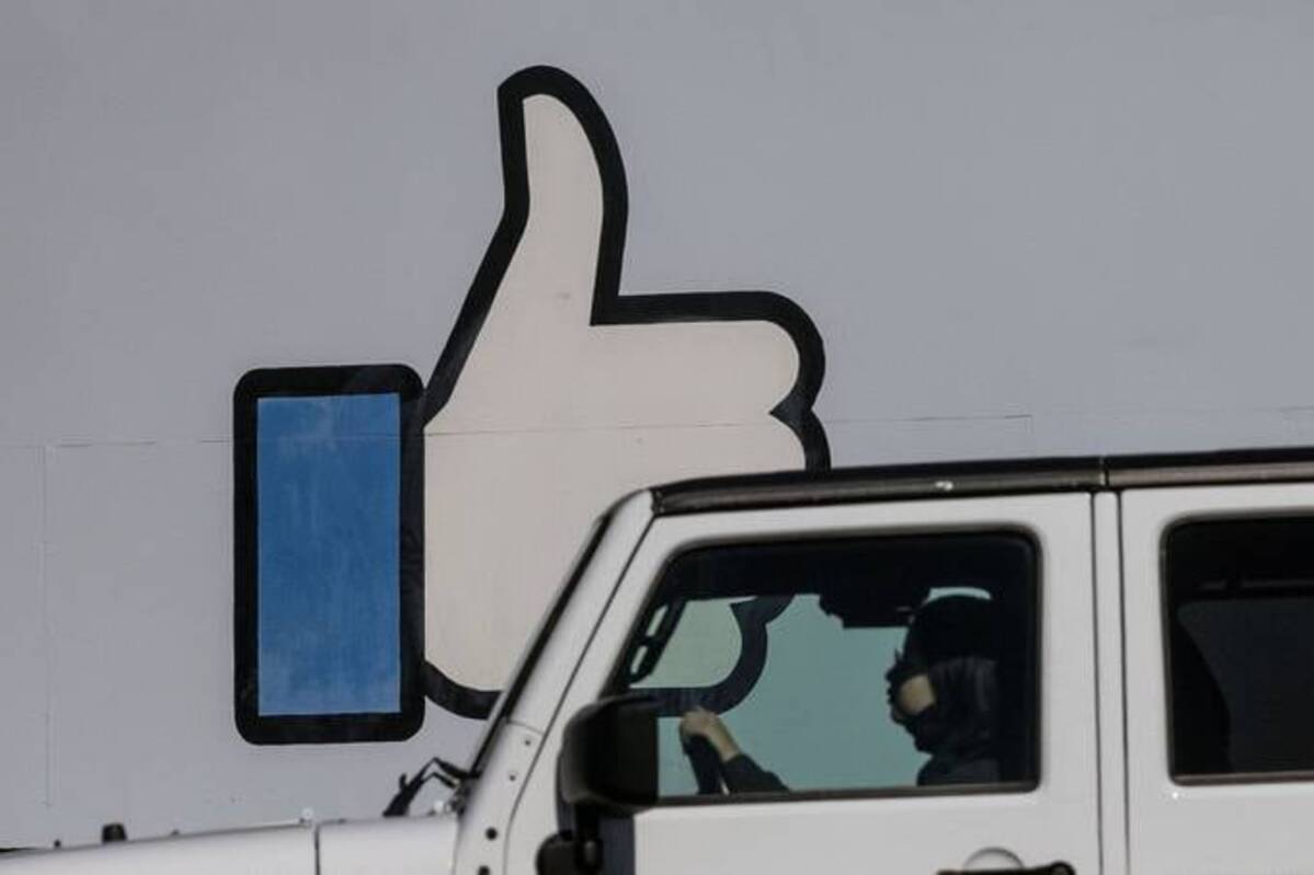 A woman drives pass the entrance sign to Facebook headquarters. (REUTERS/Carlos Barria)