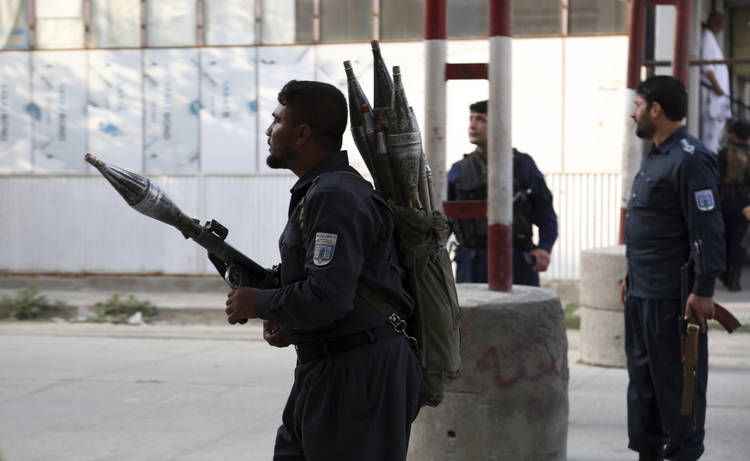 Afghan security personnel stand guard at the site of a deadly attack in Kabul on Sunday. (Rahmat Gul/AP)  