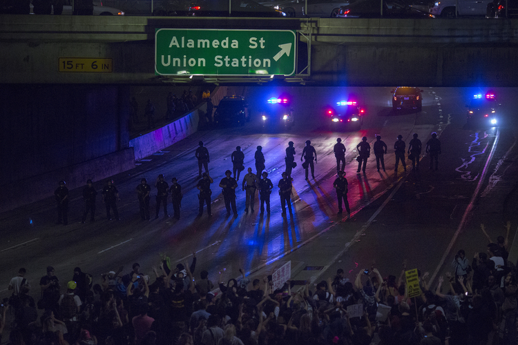 Police advance on protesters who shut down the 101 freeway in Los Angeles. Clinton actually way outperformed Obama in California. (David McNew/Getty)</p>  