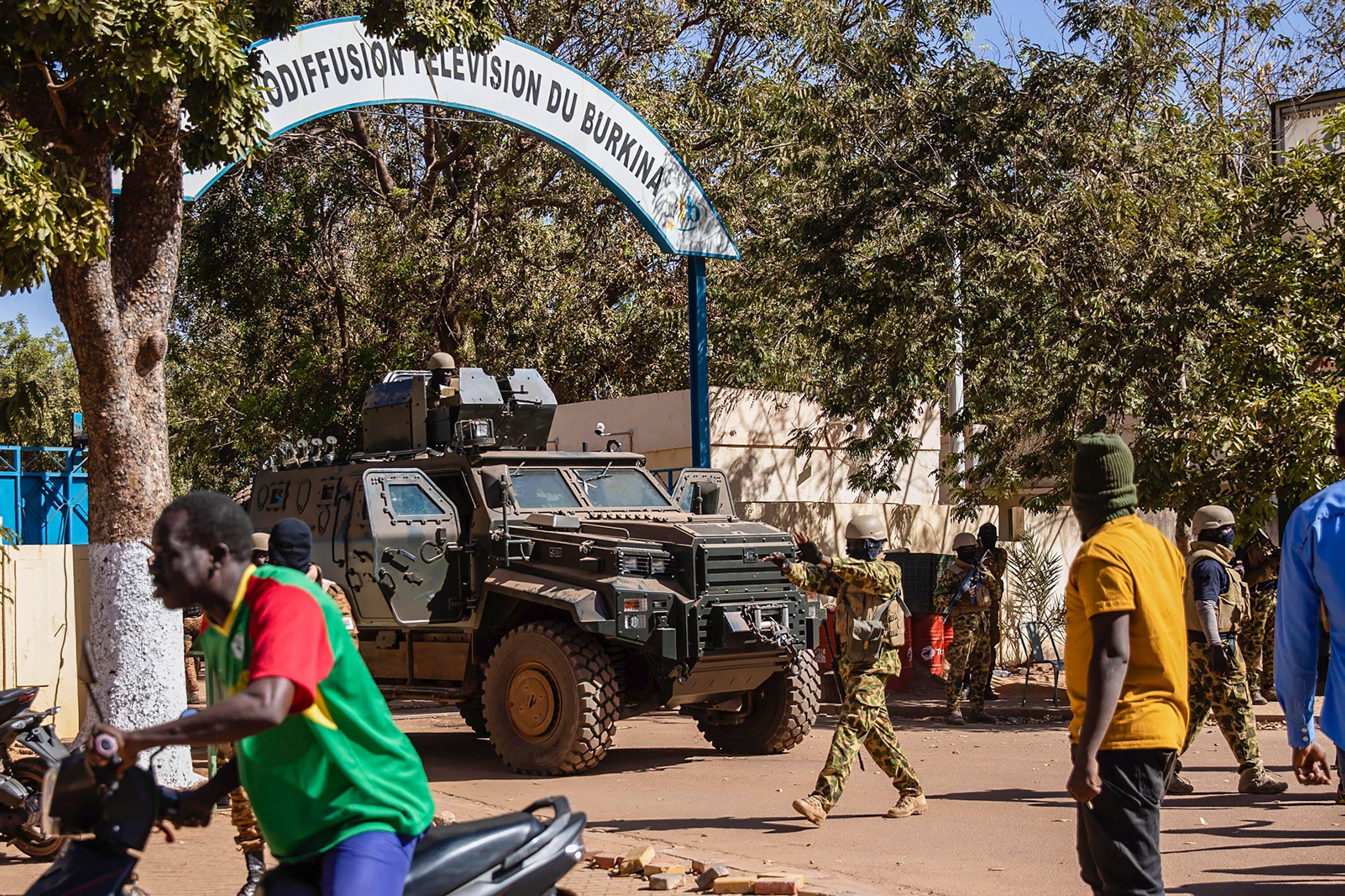 Mutinous soldiers guard the entrance of the national television station in Ouagadougou on Jan. 24. (Sophie Garcia/AP)