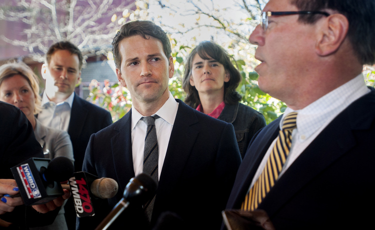 Former Rep. Aaron Schock, center, and members of his family listen as defense attorney Jeff Lang, right, speaks during a press conference yesterday outside Peoria Heights Village Hall. (Matt Dayhoff/Journal Star via AP)</p>  